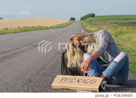 Beautiful girl hitchhiking on the road traveling. Beautiful girl hitchhiking on the road traveling. 45639600