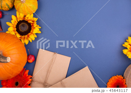 Top view of handcraft gift box with yellow and orange flowers and pumpkins on blue background. Blank 45643117