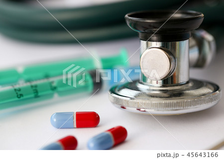 Stethoscope pile of pills fall out from jar to paper 45643166