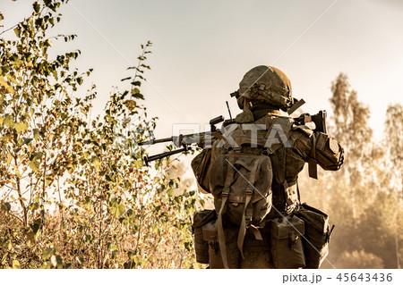 Sniper armed with large caliber, sniper rifle, shooting enemy targets on range from shelter, sitting 45643436