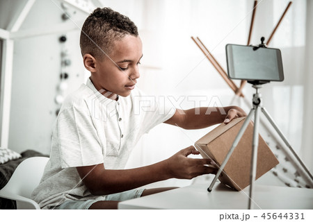 Nice cute boy opening a cardboard box 45644331