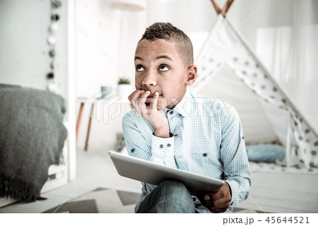 Pleasant thoughtful boy looking at the ceiling Pleasant thoughtful boy looking at the ceiling 45644521