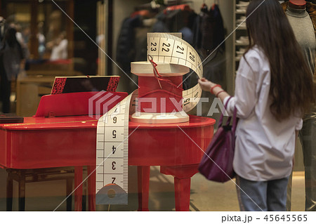 Shop window, display commercial equipment, decorative sewing needle and coil with red thread. Girl 45645565