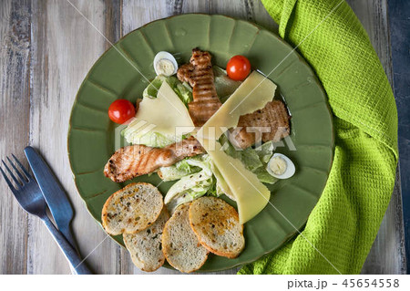 Fresh caesar salad in a green plate on a light wooden table 45654558