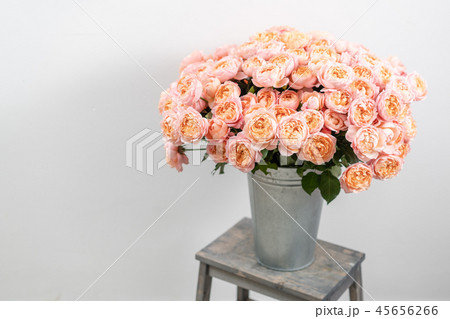 Big luxury bright bouquet peony rose on wooden table. Garden spray roses of pink and peach color 45656266