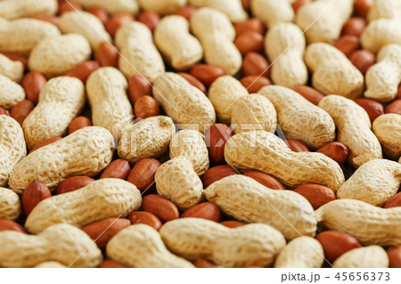 Roasted peanuts in a shell and peeled on a brown  45656373