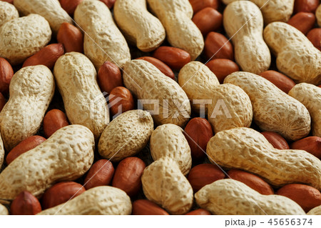 Roasted peanuts in a shell and peeled on a brown  45656374