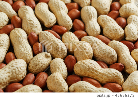 Roasted peanuts in a shell and peeled on a brown  45656375