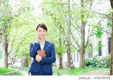 手帳を持ちながら電話をする女性 45659048