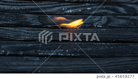 Charred wooden planks and fire. Background, texture. Please. Charred wooden planks and fire. Background, texture. Please. 45659277