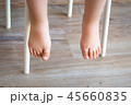 Feet of a child sitting in a chair 45660835