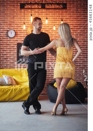 Young couple dancing latin music: Bachata, merengue, salsa. Two elegance pose on cafe with brick Young couple dancing latin music: Bachata, merengue, salsa. Two elegance pose on cafe with brick 45663148