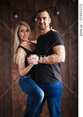 Young couple dancing latin music: Bachata, merengue, salsa. Two elegance pose on cafe with brick 45663223