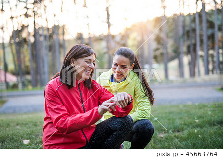 Female runners with smartwatch outdoors in park in nature, checking the time. Female runners with smartwatch outdoors in park in nature, checking the time. 45663764