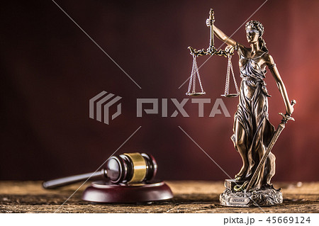 Lady Justicia holding sword and scale on table. 45669124