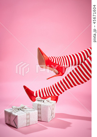 sexy santa woman's legs on a pink background and Christmas gifts 45671604