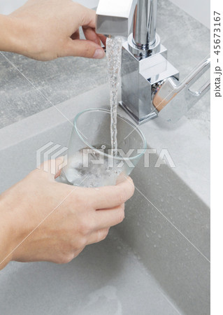 Hand holding a glass of water poured  45673167