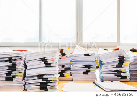 Pile of unfinished documents on office desk. 45685356