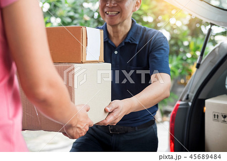 Woman receiving parcel cardboard box from delivery man Carrying Woman receiving parcel cardboard box from delivery man Carrying 45689484