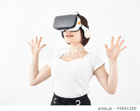 白い背景でVRヘッドマウントディスプレイをつけて驚く女性 45691360