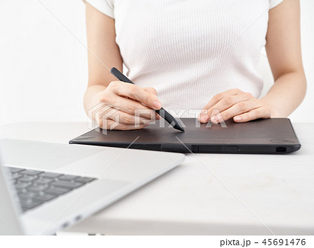 ペンタブレットでイラストを描く女性の手元の写真素材