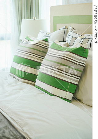 Green stripped pillows on bed in modern bedroom 45692327