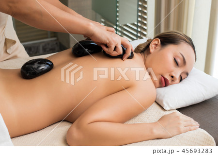Body Massage on naked back of Mix Race Caucasian Asian woman by pressing fingers on pain or stress muscle point to release relax. Therapist Spa body massage woman hands treatment on customer Body Massage on naked back of Mix Race Caucasian Asian woman by pressing fingers on pain or stress muscle point to release relax. Therapist Spa body massage woman hands treatment on customer 45693283