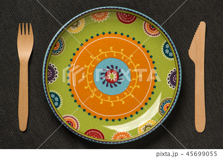 Plate with an ornament and a wooden knife and fork 45699055