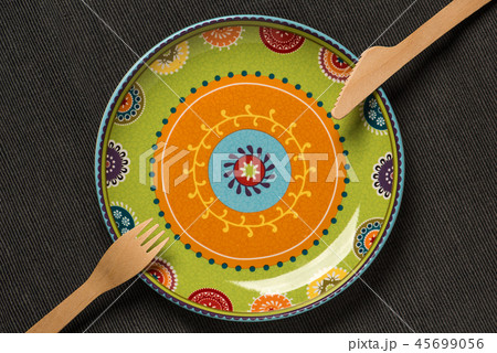 Plate with an ornament and a wooden knife and fork 45699056