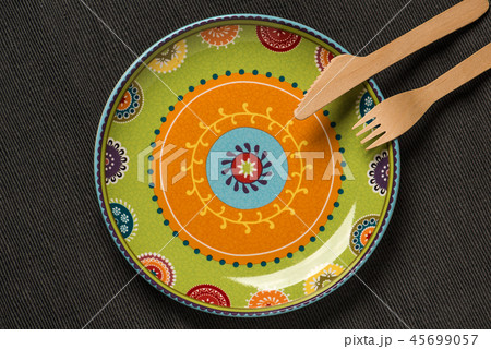 Plate with an ornament and a wooden knife and fork 45699057