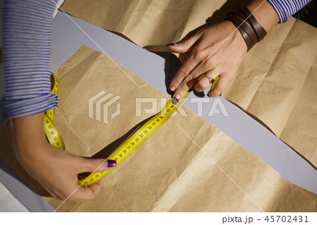 Close-up of a seamstress's hand with a centimeter Close-up of a seamstress's hand with a centimeter 45702431