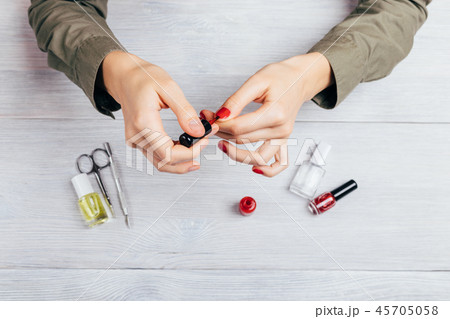 Young woman apply red polish 45705058