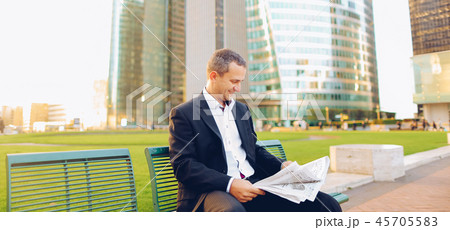 Gladden male manager reading newspaper outside in  . 45705583