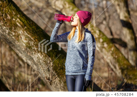 Young runner girl with bottle of water in the park Young runner girl with bottle of water in the park 45708284