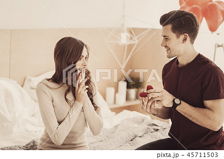 Charming girlfriend feeling shocked while receiving unbelievable engagement ring 45711503