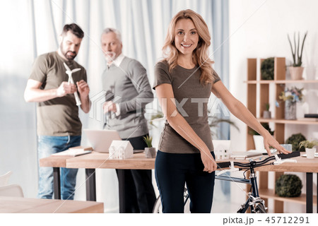 Delighted woman standing with her bike 45712291
