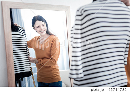 Pleasant beautiful woman looking into the mirror 45714782