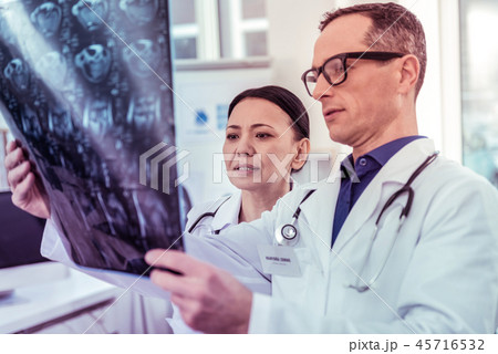 Attentive concentrated medical workers examining X-ray photo 45716532