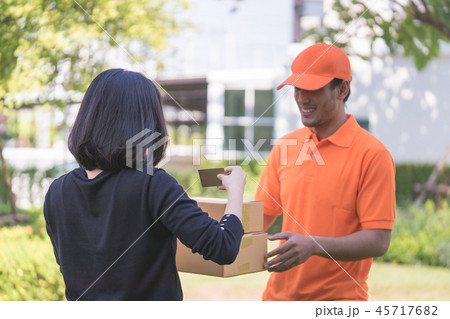 Woman using credit card to pay for delivery. 45717682