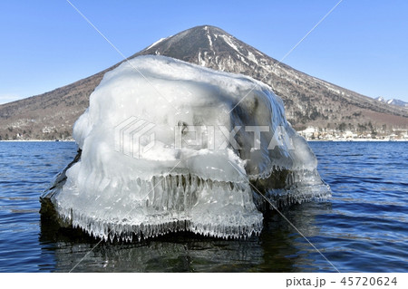 冬の中禅寺湖　しぶき氷付く岩と男体山 45720624