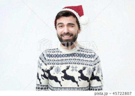 Religious cheerful hispanic male in red christmas hat with happy expression Religious cheerful hispanic male in red christmas hat with happy expression 45722807