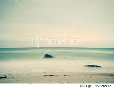 Sand of beach with soft waves and pebbles, morning 45726942