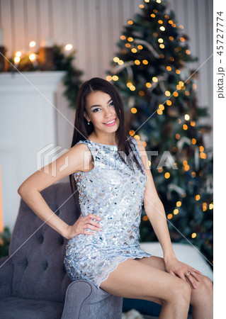 Beautiful girl near the Christmas tree. Girl in a smart dress at Christmas. 45727774