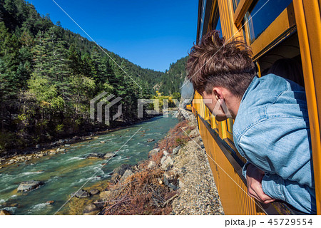 Young man looking out of train window Young man looking out of train window 45729554