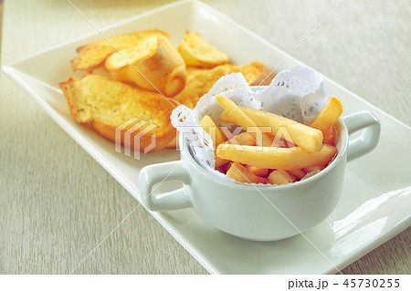 close-up of french fries in cup with garlic bread 45730255