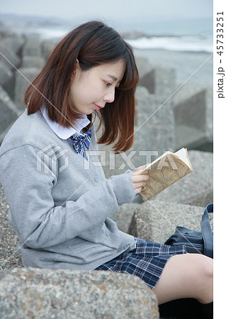 野外で読書する女子高生の写真素材