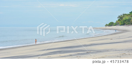 Two People in the distance on an empty beach. Two People in the distance on an empty beach. 45733478