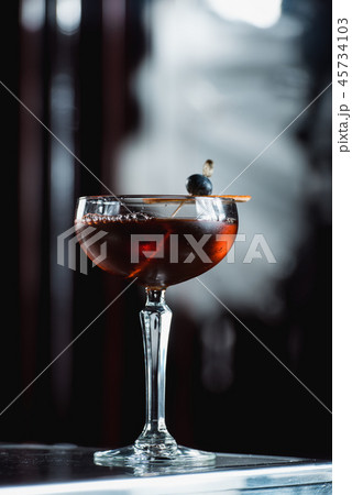 The Boulevardier Cocktail with orange chips on top. On a bar desk The Boulevardier Cocktail with orange chips on top. On a bar desk 45734103