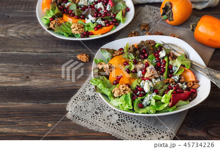 Salad with persimmon, pomegranate and blue cheese Salad with persimmon, pomegranate and blue cheese 45734226
