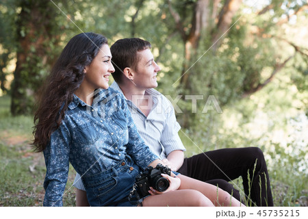 young couple sitting in forest, romantic feelings young couple sitting in forest, romantic feelings 45735215